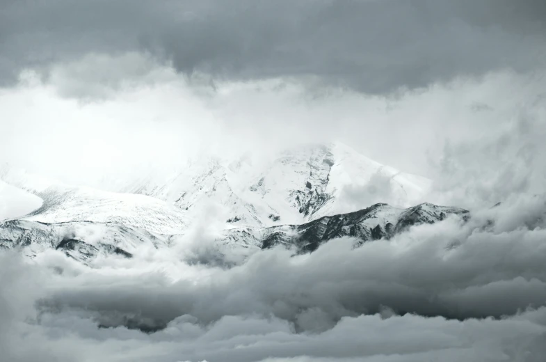 an airplane flies in front of the snow capped mountains