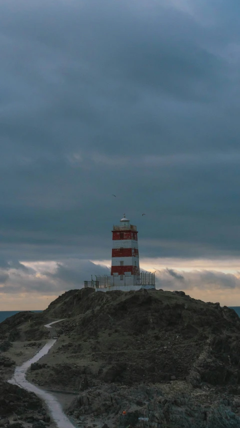 a lighthouse is on the top of the hill