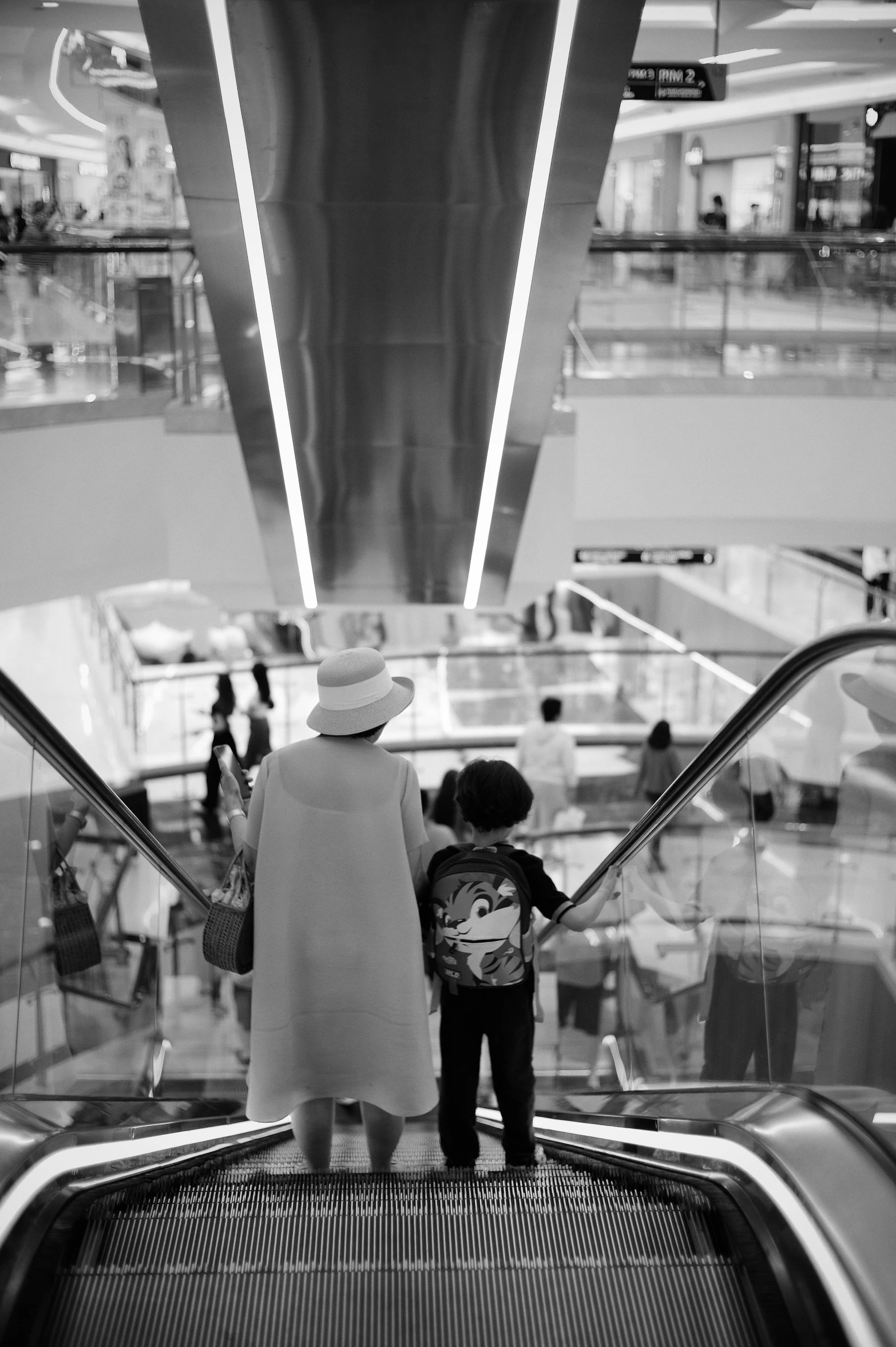 two children on an escalator looking at escalators