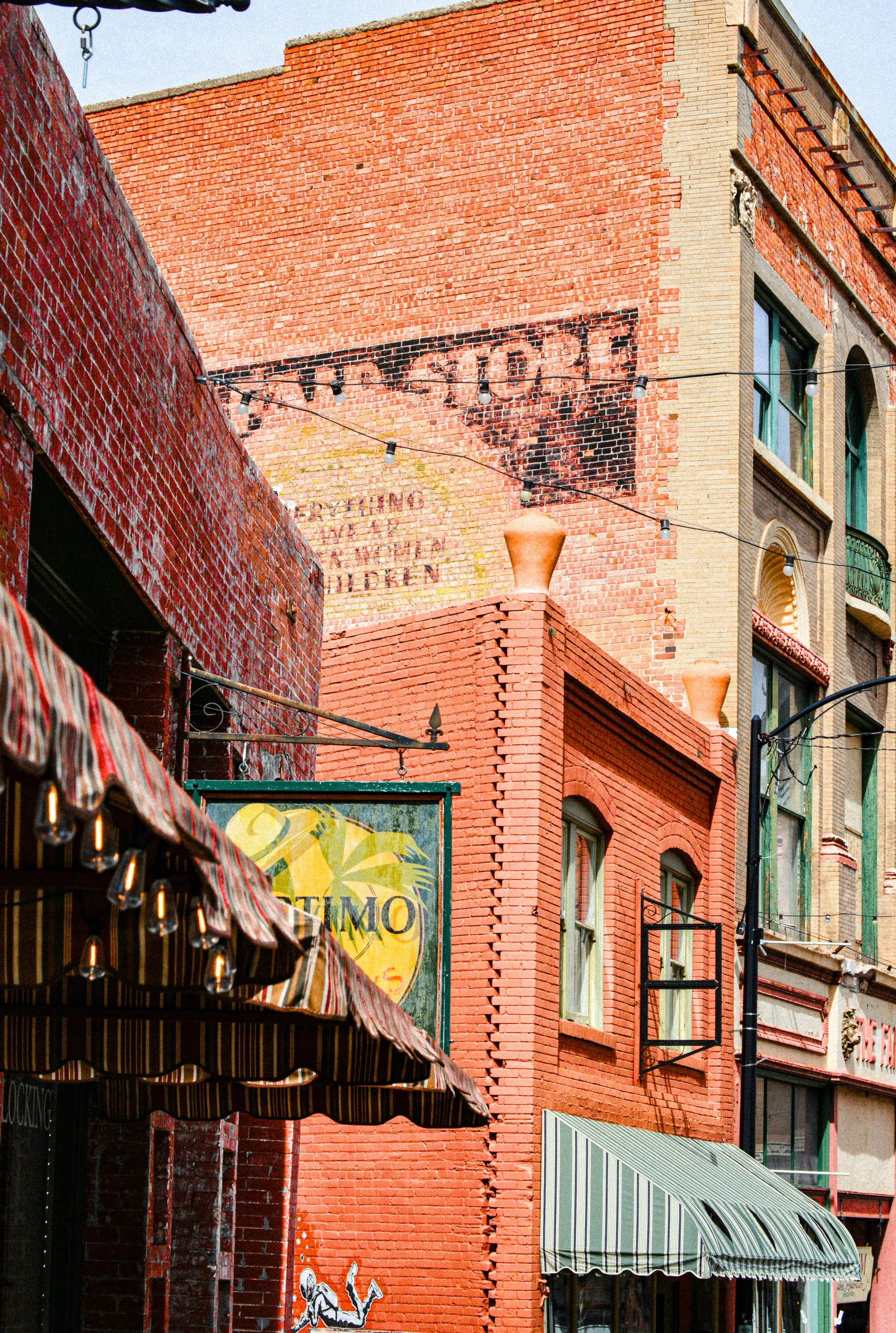 an alleyway with small businesses and stores along a city street