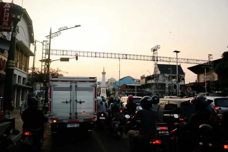 many people ride motorcycles near some shops