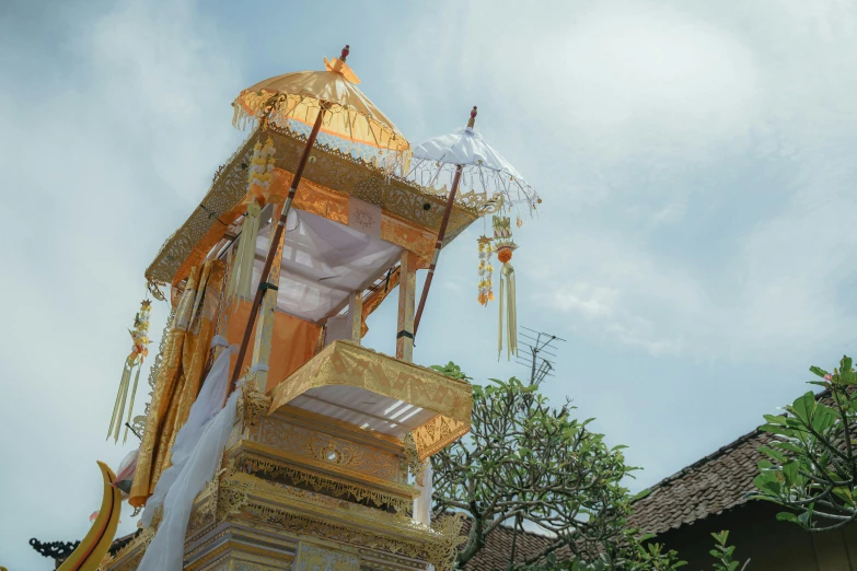 a group of large gold and white flags on top of a tower