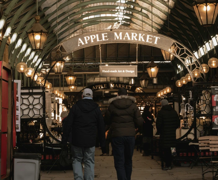 the inside of an apple market showing people walking