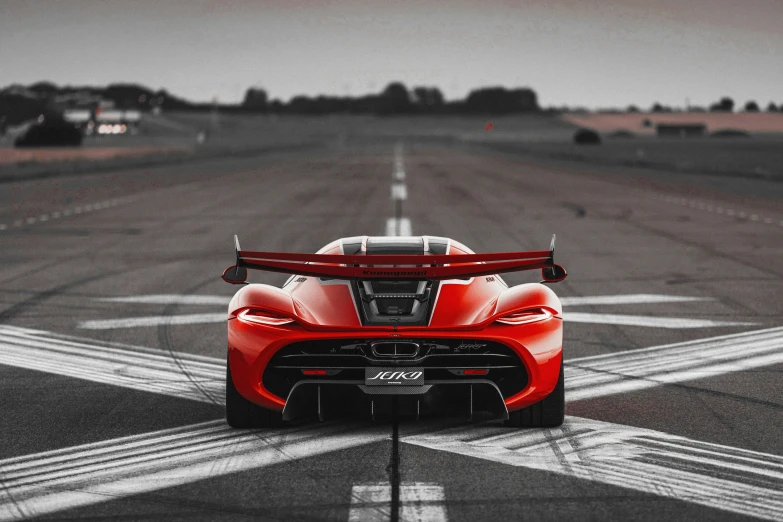 a red sports car driving down the road