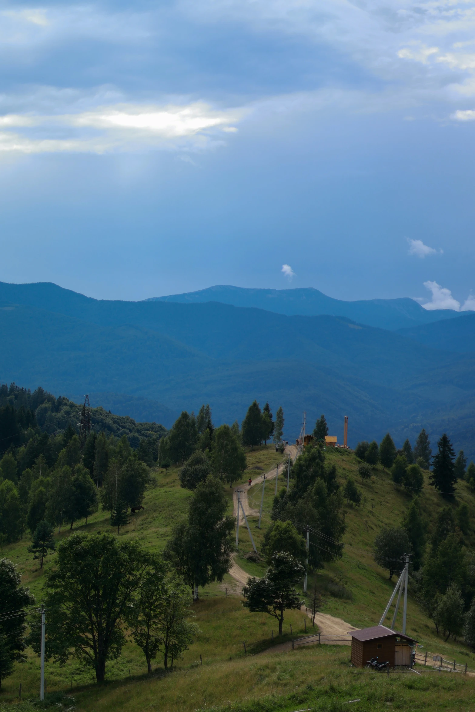 a mountain range with a house and a gate