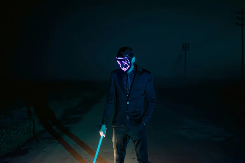 a man standing with skis in the dark wearing a neon mask