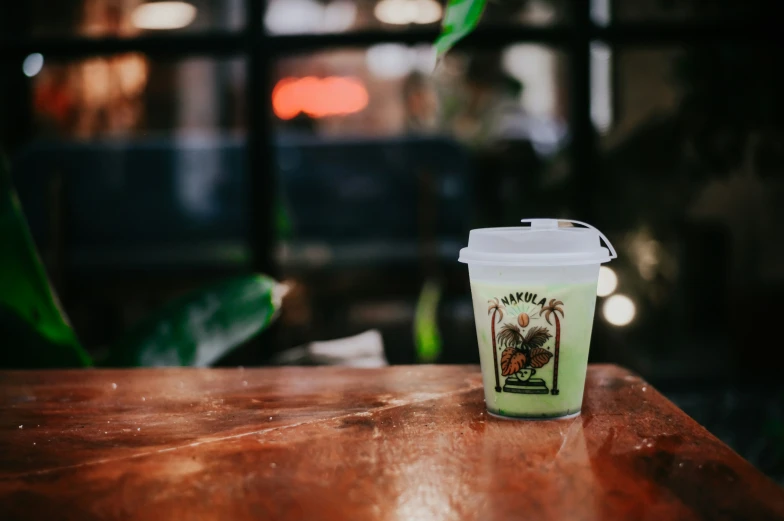 a cup with a lid and cap is shown on a table