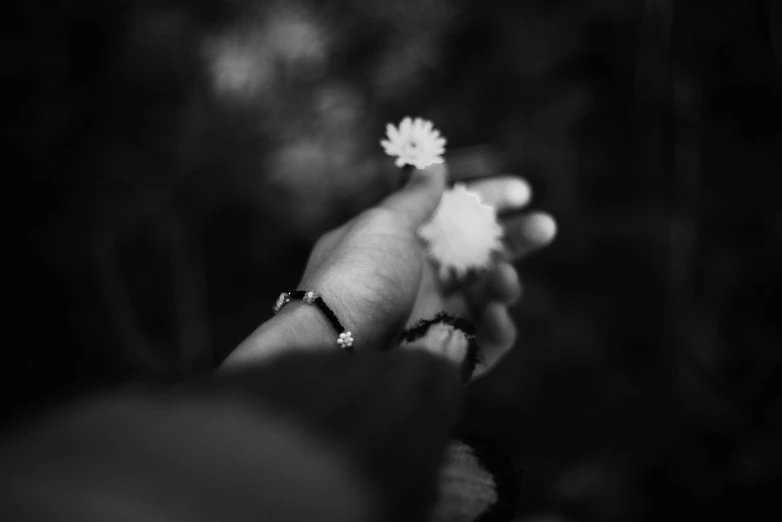 a woman holding a white flower with her right hand