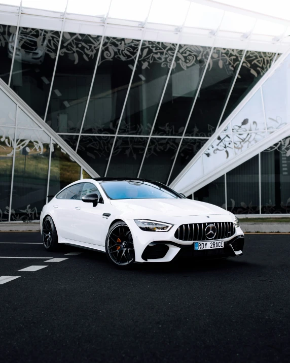 white sports car parked outside an elegant building