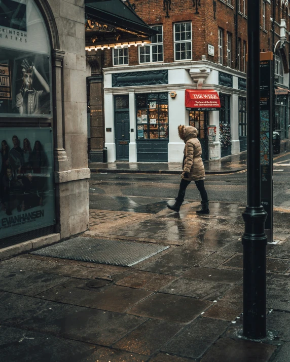 a person crossing a city street in the rain