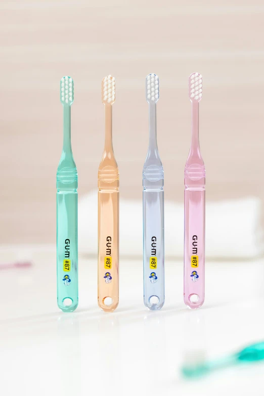 three different colored toothbrushes standing in a row