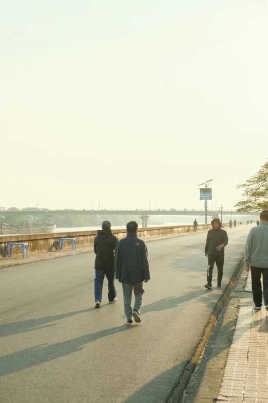 several people are walking down the street in a cold day