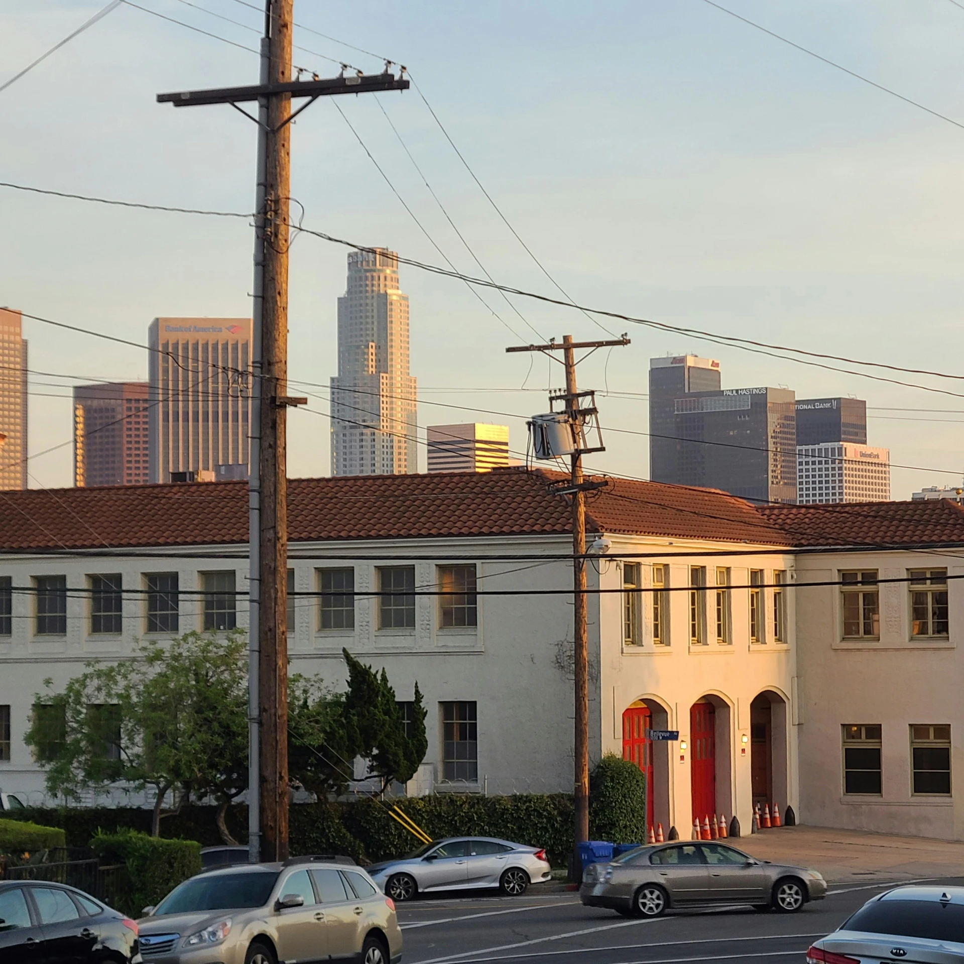 several cars stopped at an intersection with many buildings in the background