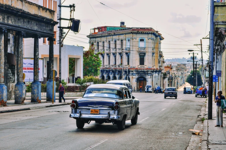 a car driving down a street next to two old buildings