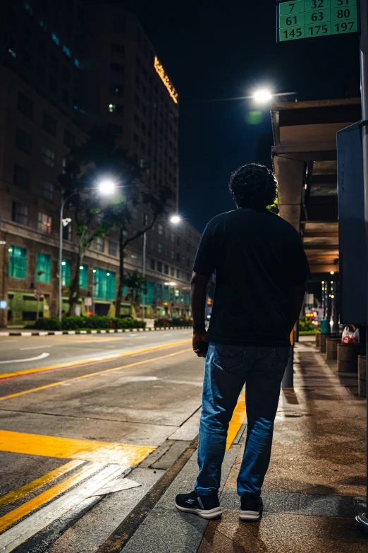 a man stands in the dark by a city street