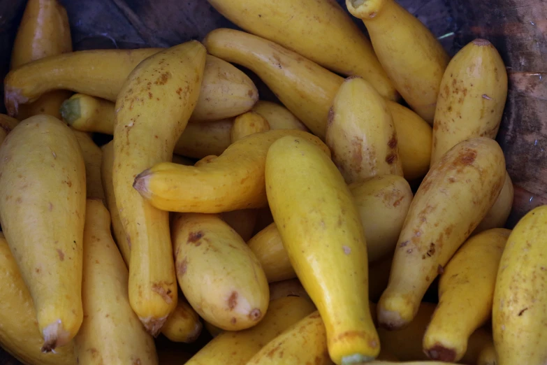 a pile of yellow and brown fruits with tiny bumps