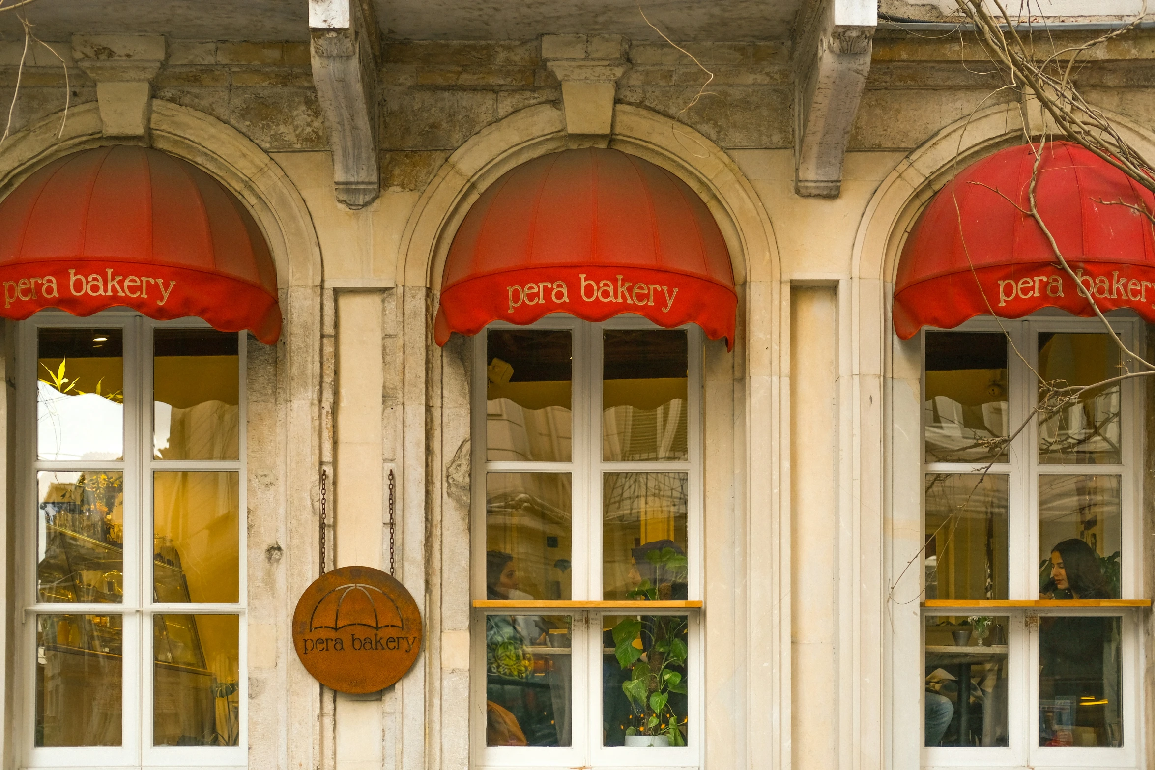 the windows have red awnings outside the shop