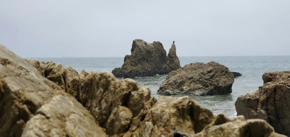 a person is standing on a rocky shore