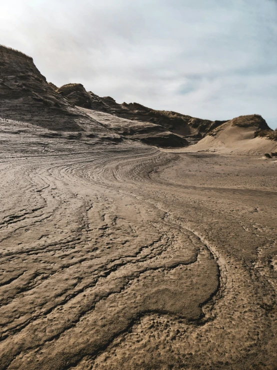 a trail in the middle of a desert near large mountains