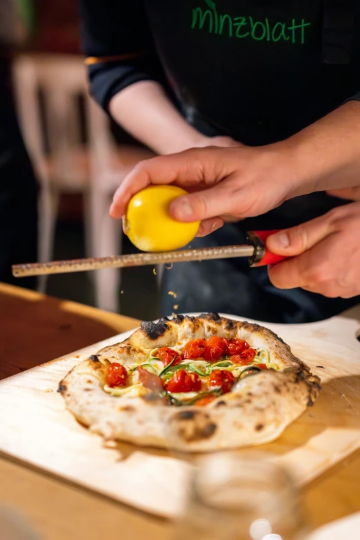 a person is peeling tomatoes and making pizza