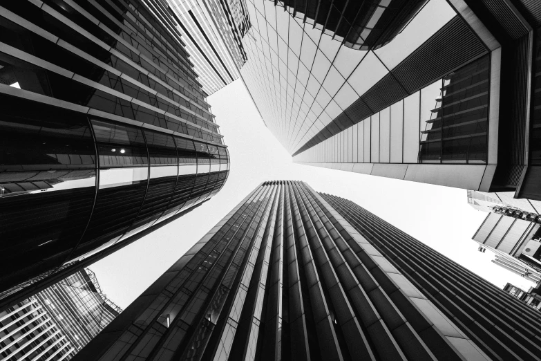 several tall buildings from below, with glass windows