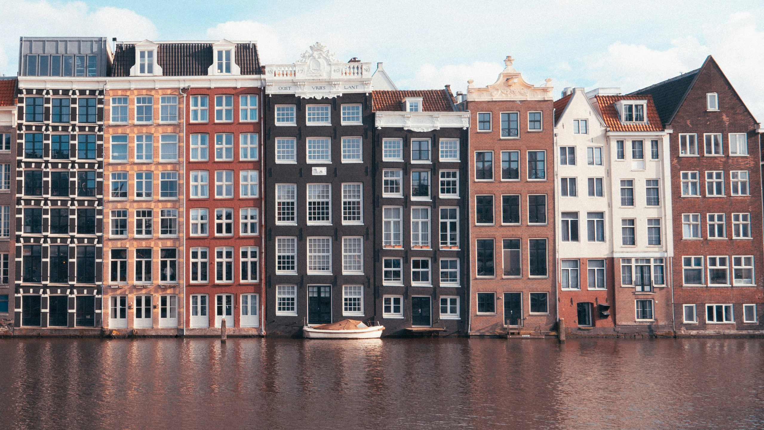 the large group of buildings next to each other are all reflecting off the water