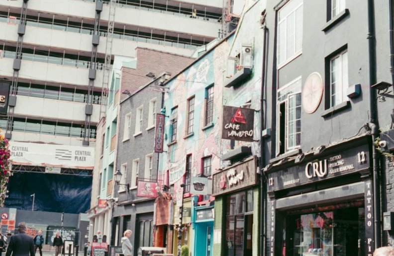 people walking down a street in an alley next to a row of buildings