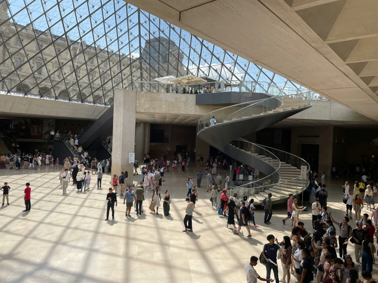 large room with stairs and a lot of people walking around