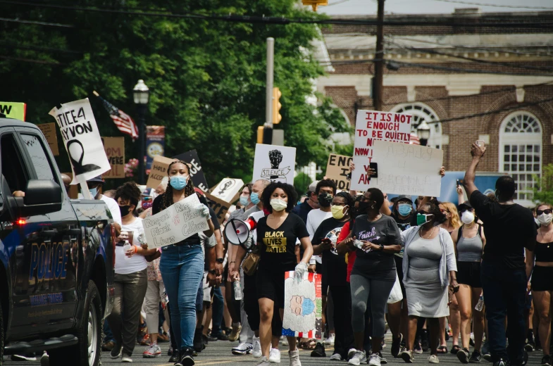 a large group of people are walking with protest signs