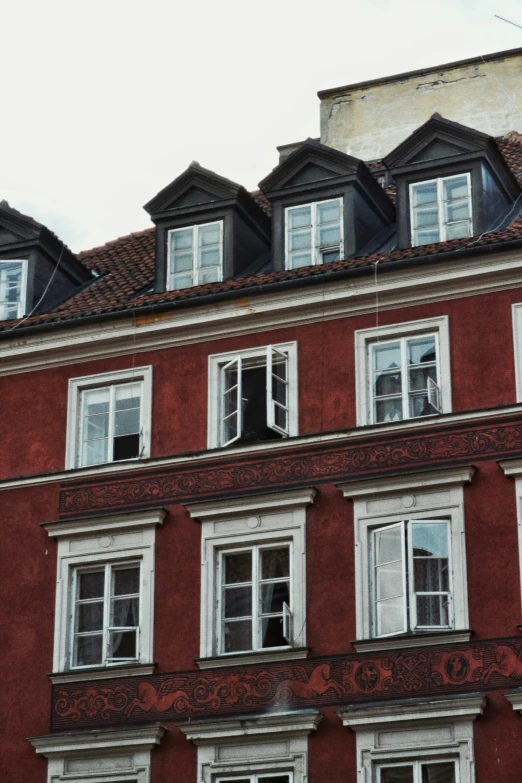 an older red building has white windows and white shutters