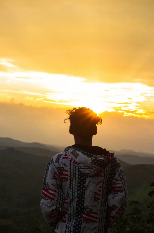 a person with their back to the camera and his hair up at sunrise