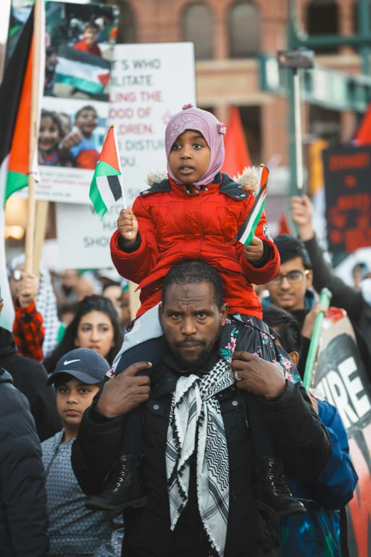 a young child is held up by his mother in the middle of a protest