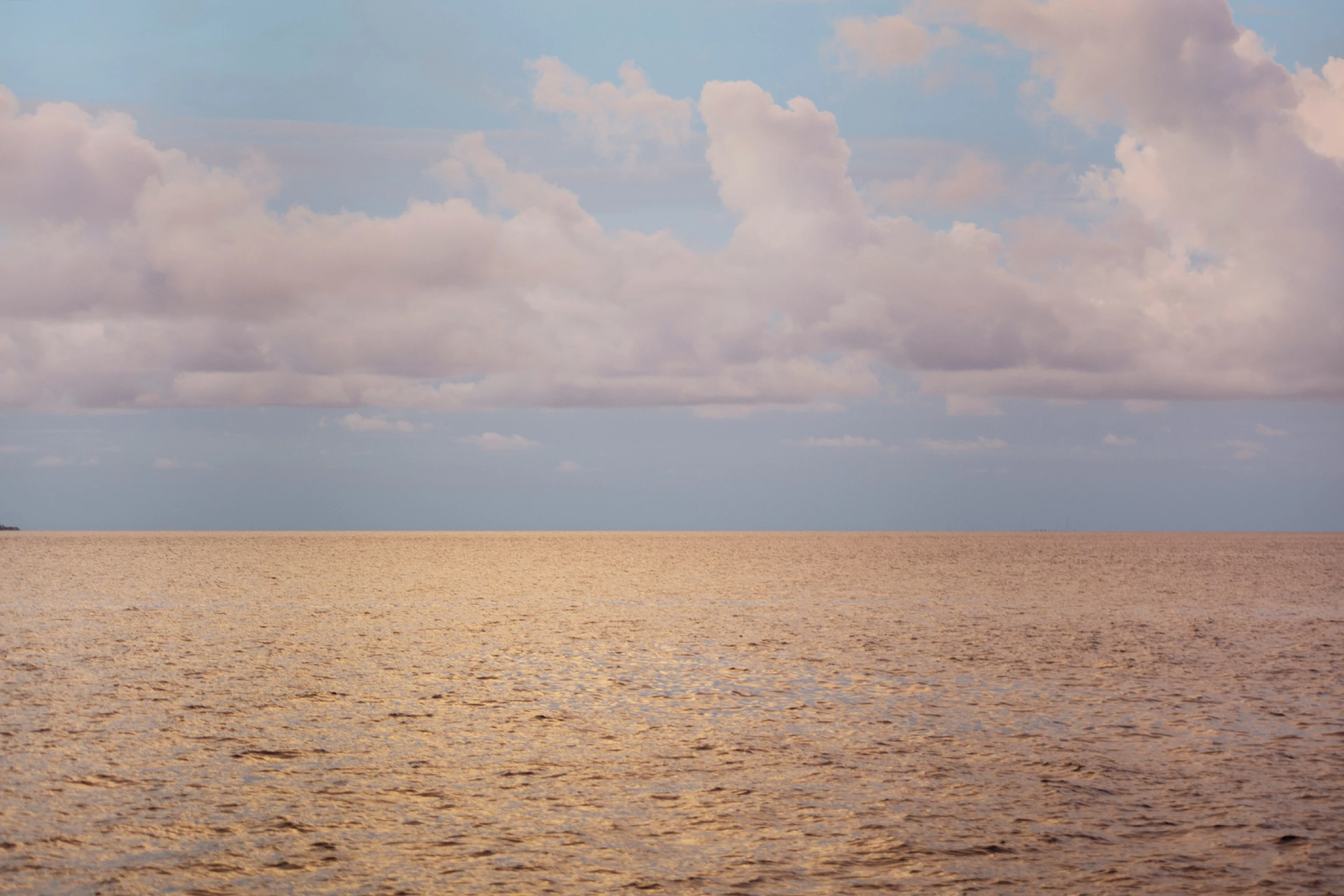 a boat in a large body of water under clouds