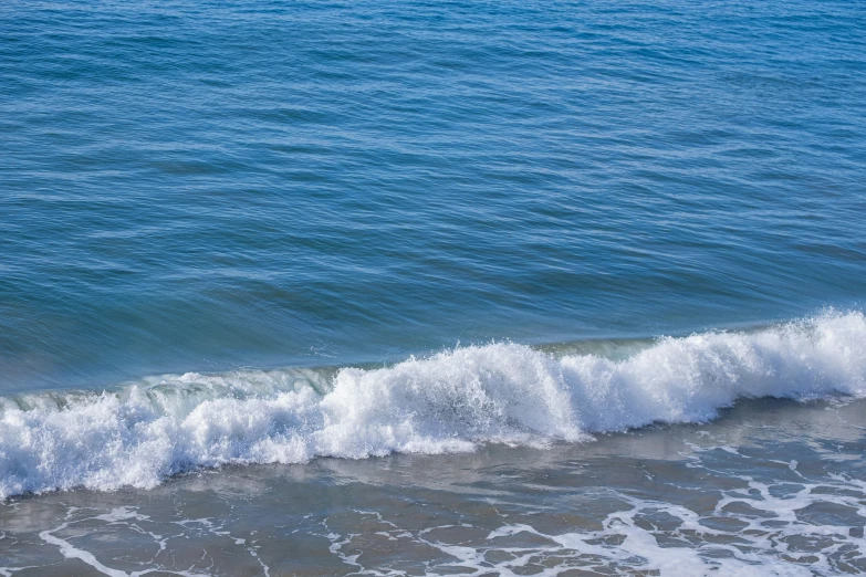 the ocean has rough white, foamy water