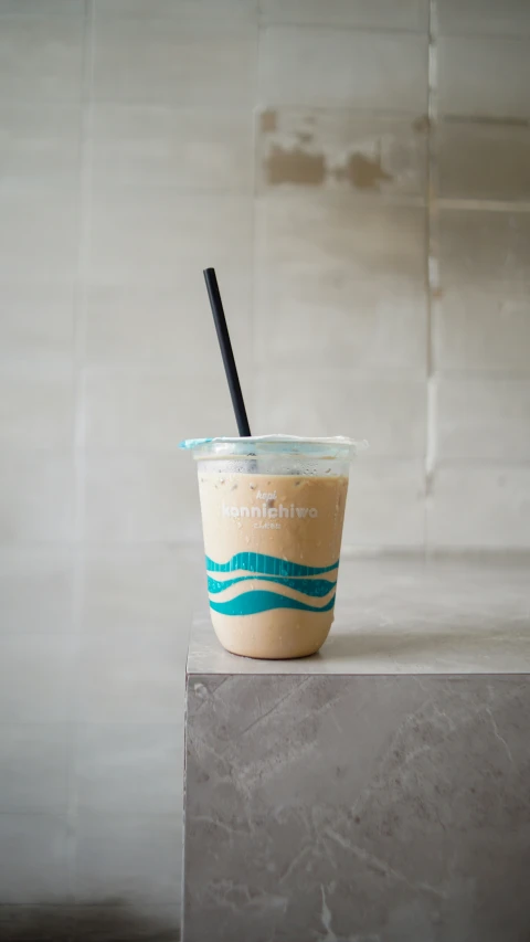 a cup with a black straw sitting on top of a table