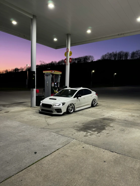 a white sports car parked at a gas station