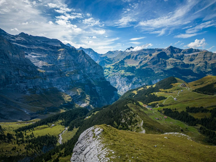 a group of mountains on the side of a hill with many trees around it