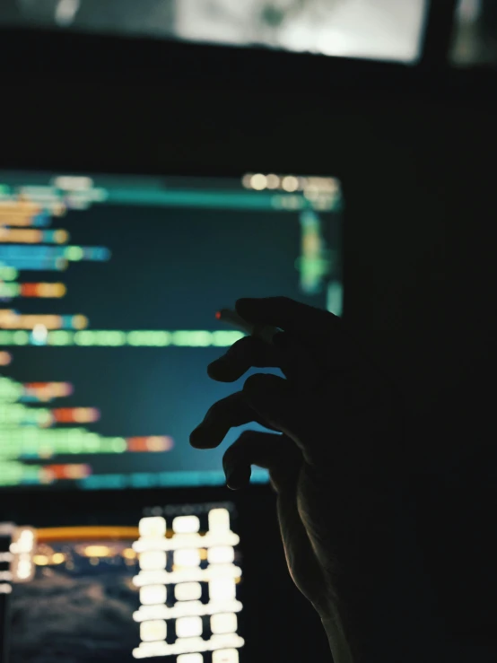 person reaching up in front of an open laptop computer