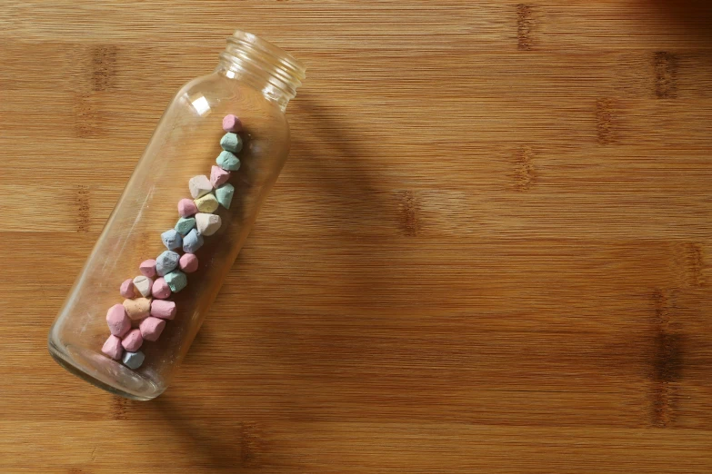 some tiny beads in a bottle on a table