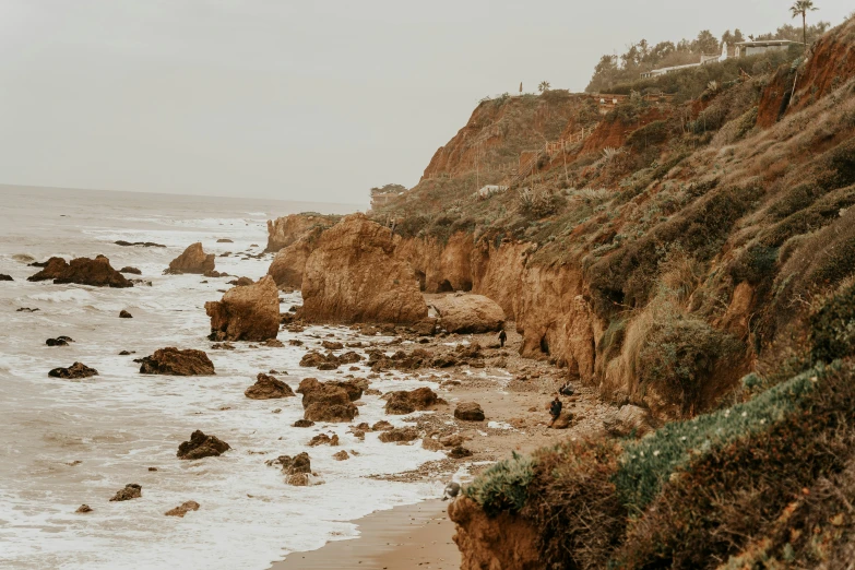 the cliff is next to the ocean with water in it