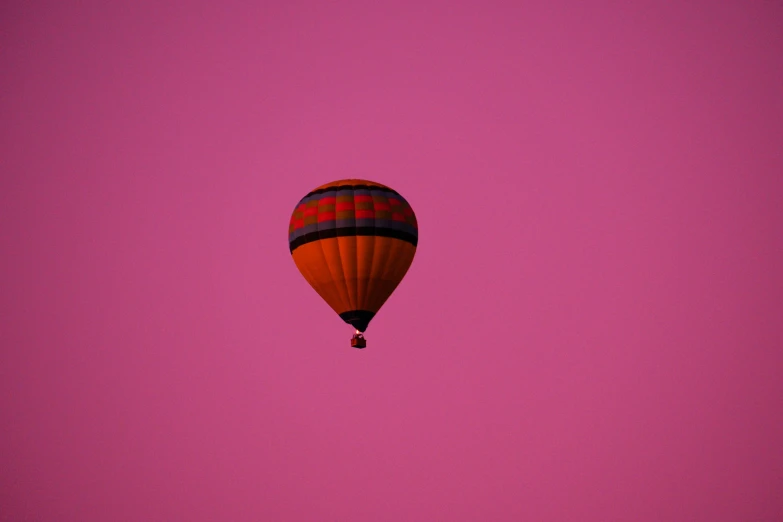 the  air balloon is flying through the sky