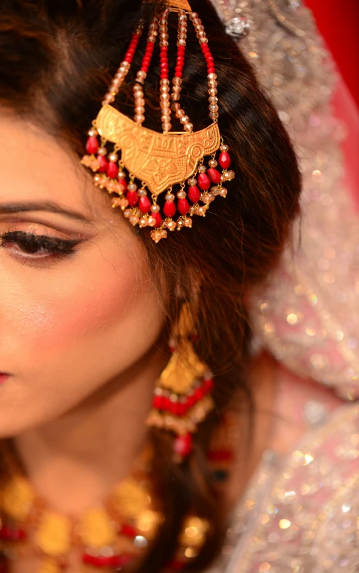 a woman in a red and gold necklace and headpiece