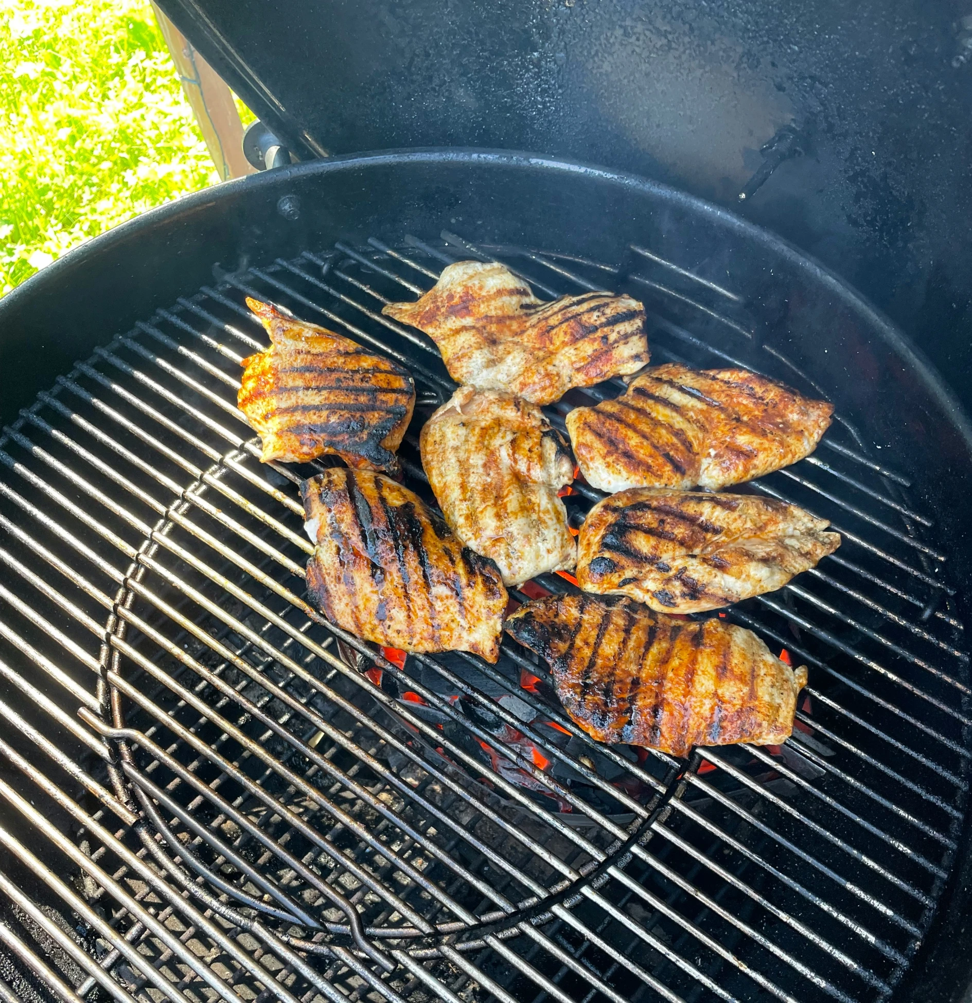 barbecue grill with several pieces of meat on top