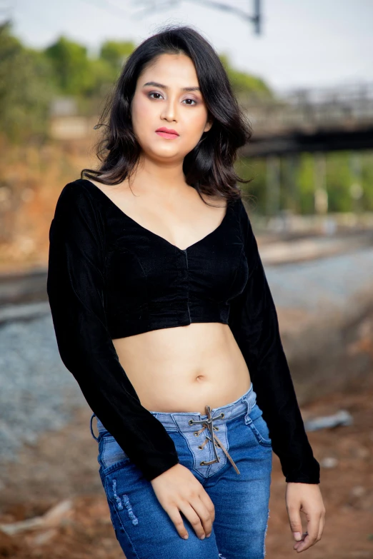 a woman posing in jeans and a crop top