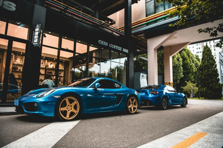 this blue sports car is parked beside another