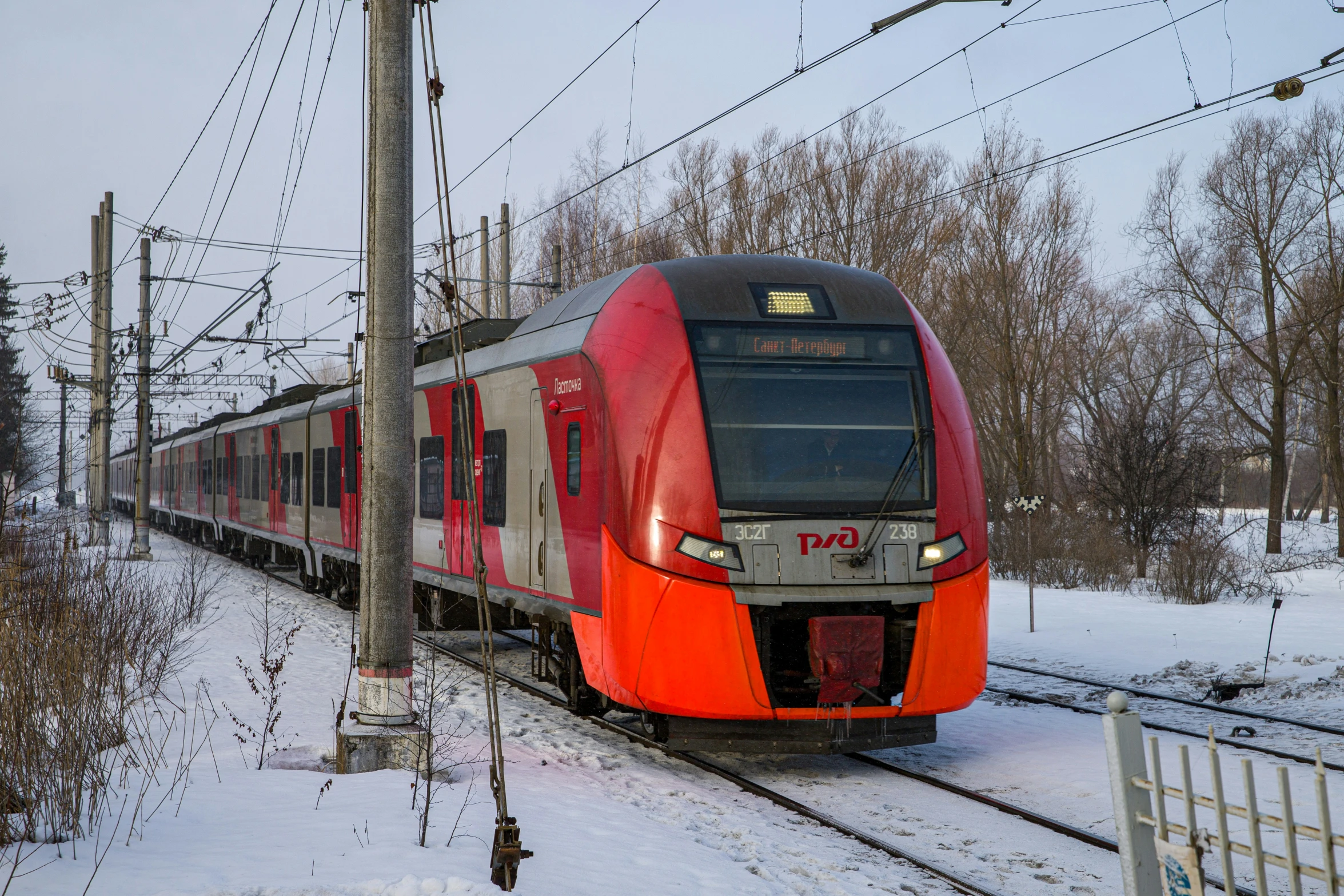 a passenger train travels down the tracks through the snow