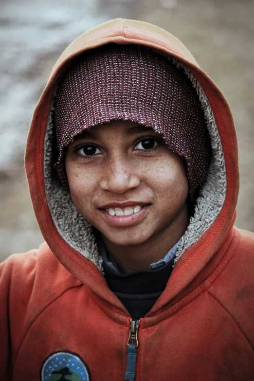 a young child is wearing a hooded sweater