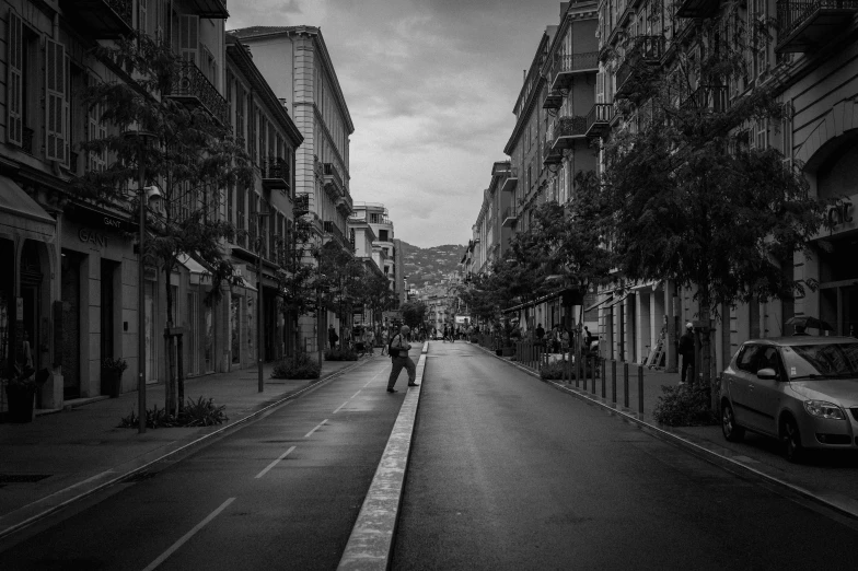 an empty street in black and white with some trees on the side