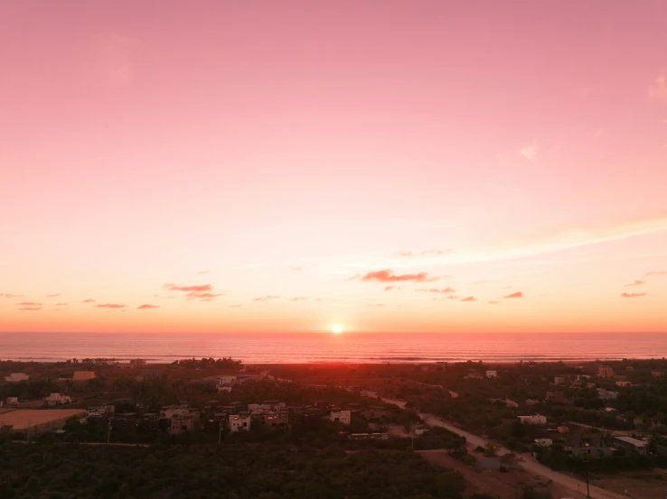 the sun rising over a beautiful beach as seen from an air plane