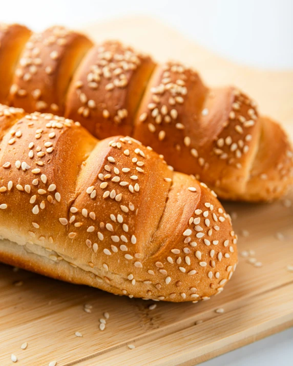 a group of breads are sitting on a wooden board